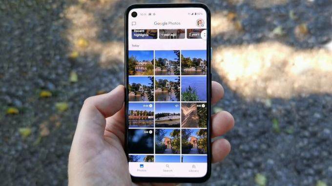 Aplikacija Google Photos v telefonu Pixel 4a, ki jo držite v eni roki na prostem.